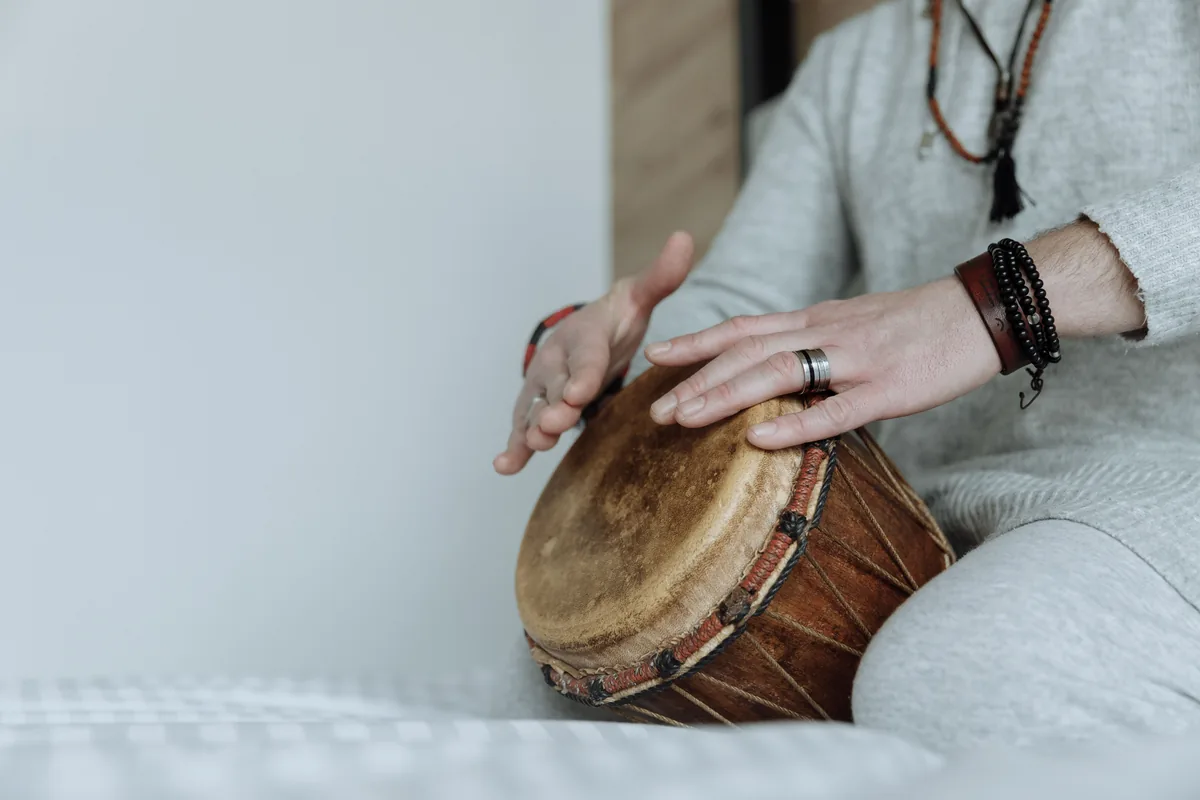 Hands playing a djembe drum during an interactive drumming session